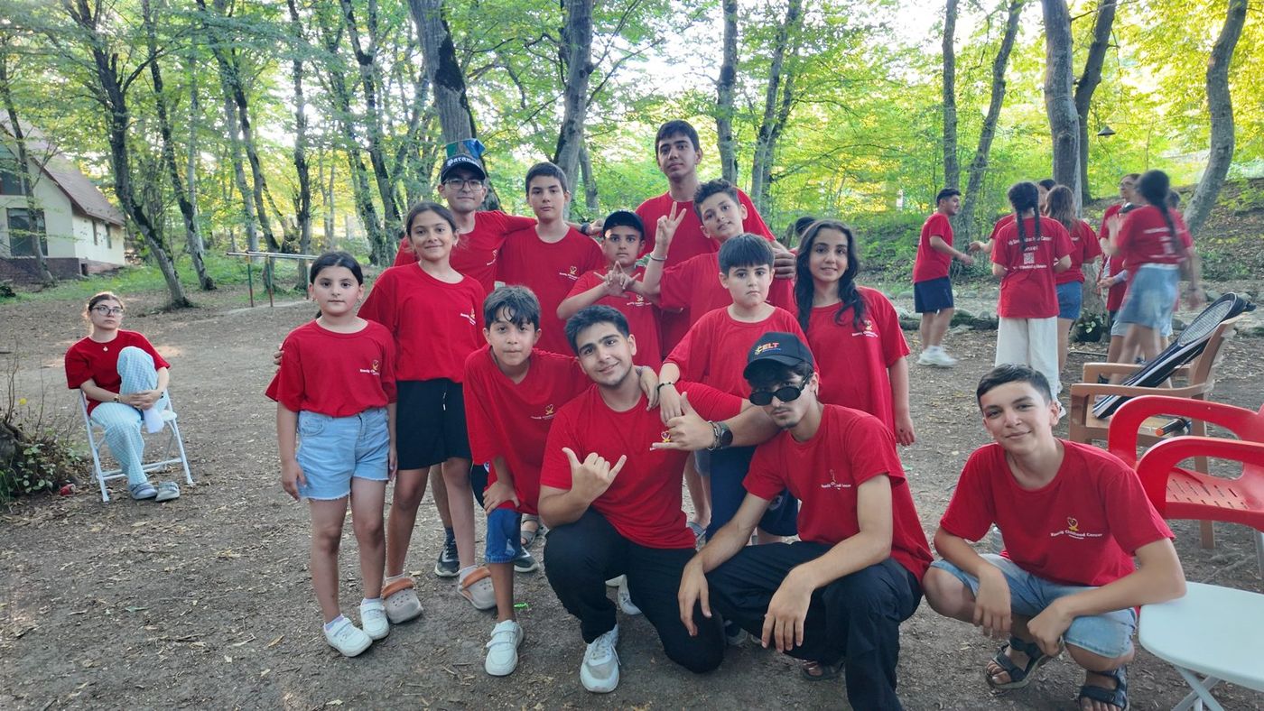 Campers in red KCCF shirts together in a forest
